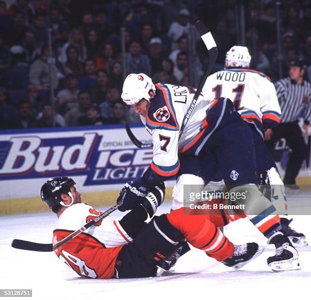 Scott Lachance of the New York Islanders does his best to keep Eric Lindros out of the play.