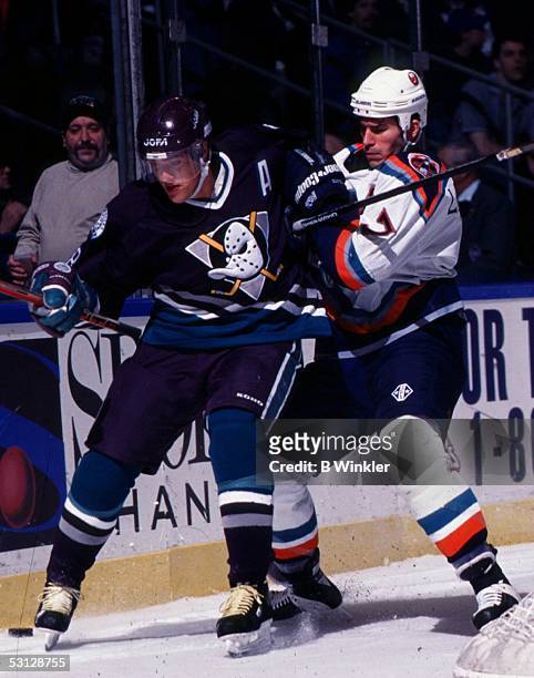 Teemu Selanne of the Mighty Ducks of Anaheim and Scott LaChance of the New York Islanders battle for puck posession.