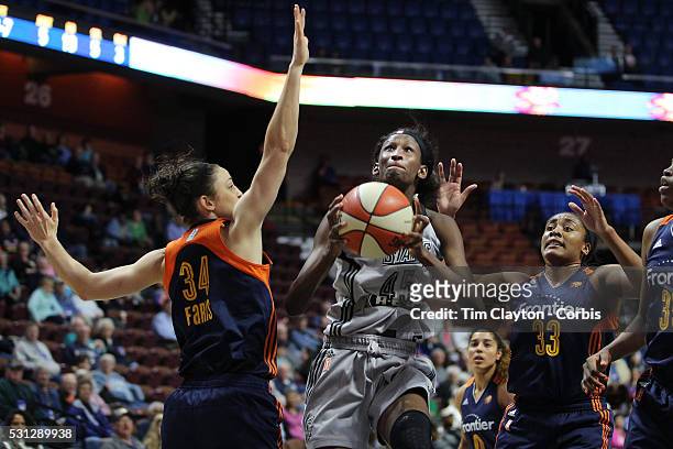 Astou Ndour, , of the San Antonio Stars drives to the basket challenged by Kelly Faris, and Morgan Tuck of the Connecticut Sun during the San Antonio...