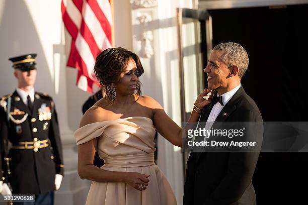 First Lady Michelle Obama touches U.S. President Barack Obama's chin as they wait for leaders to arrive for the Nordic state dinner on the North...