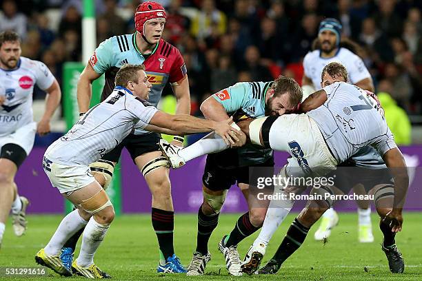 Akapusi Qera of Montpellier is tackled by Joe Marler of Harlequins during the European Rugby Challenge Cup Final match between Harlequins and...