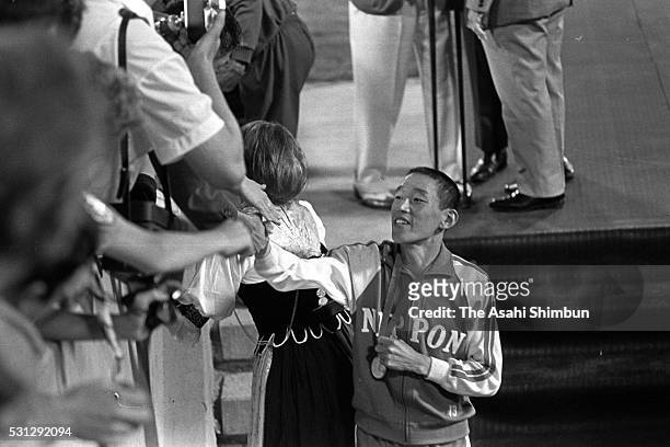 Silver medalist Kenji Kimihara of Japan shake hands with fans after the medal ceremony for the Men's Marathon during the Mexico City Summer Olympic...