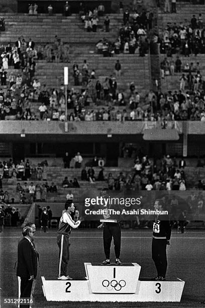 Silver medalist Kenji Kimihara of Japan, gold medalist Mamo Wolde of Ethiopia and bronze medalist Mike Ryan of New Zealand are seen on the podium at...