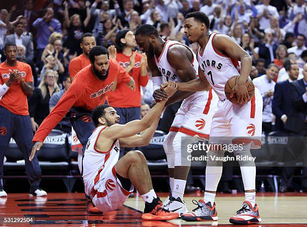 Cory Joseph of the Toronto Raptors is helped up by Patrick Patterson and Kyle Lowry after being fouled in the first half of Game Five of the Eastern...
