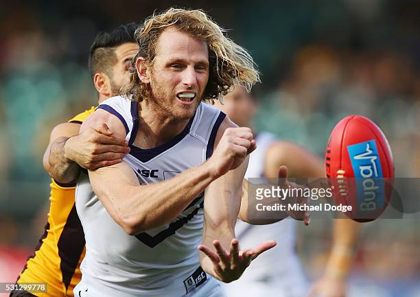 David Mundy of the Dockers handballs away from Paul Puopolo of the Hawks during the round eight AFL match between the Hawthorn Hawks and the...