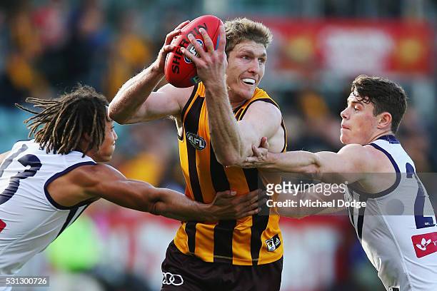 Ben McEvoy of the Hawks looks upfield from Tendai Mzungu of the Dockers and Lachie Neale during the round eight AFL match between the Hawthorn Hawks...