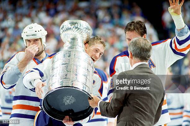 President John Ziegler presents Wayne Gretzky, Mark Messier and Kevin Lowe of the Edmonton Oilers the Stanley Cup Trophy after the Oilers Game 4 win...