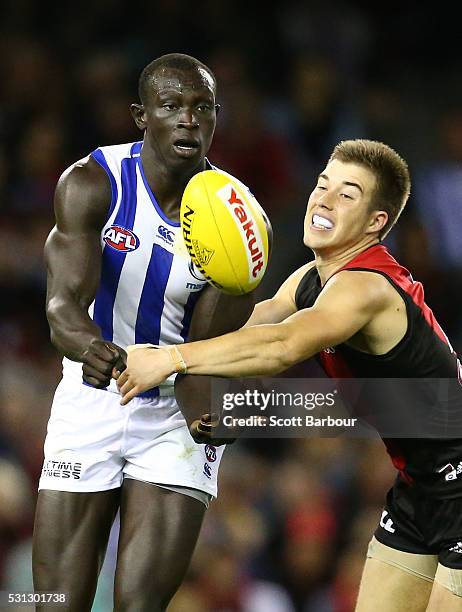 Majak Daw of the Kangaroos is tackled by Zach Merrett of the Bombers during the round eight AFL match between the Essendon Bombers and the North...