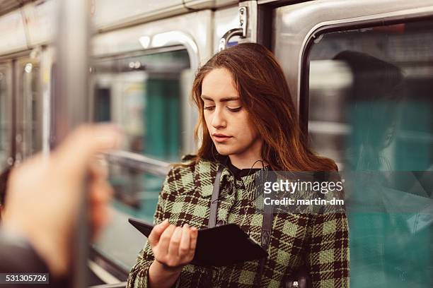 woman reading e-book in the subway - cable car stockfoto's en -beelden