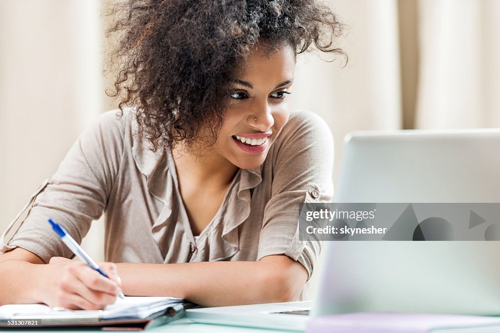 Smiling female student studying at home.