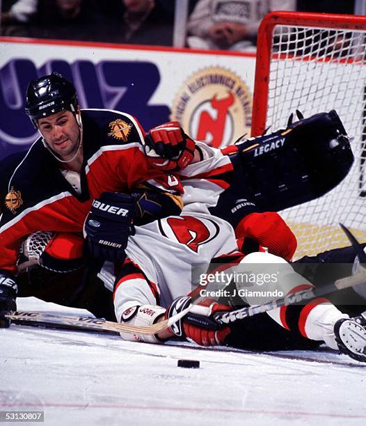 Jeff Norton of the Panthers puts a head lock on one of the Devils in a wild scramble for the loose puck.
