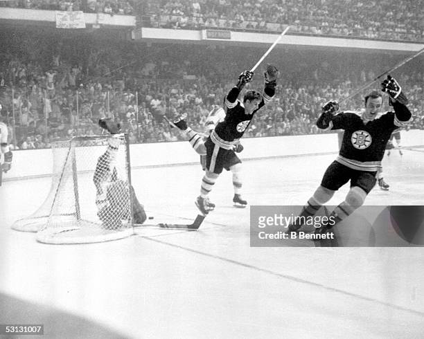 Bobby Orr of the Boston Bruins flies through the air after sliding the puck past goalie Glenn Hall and tripped by Noel Picard of the St. Louis Blues...