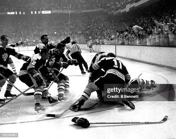 Bobby Orr of the Boston Bruins is mobbed by teammates Derek Sanderson and Wayne Carleton after Orr scored the game winning, overtime goal against the...