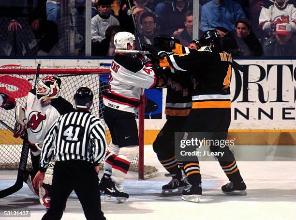 Scott Stevens, Kevin Hatcher and unknown Penguin blast each other in front of NJ goaltender Martin Brodeur.