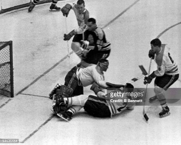 Goalie Jacques Plante and teammate Doug Harvey of the Montreal Canadiens block a shot by Willie O'Ree of the Boston Bruins as Canadiens J.C. Tremblay...