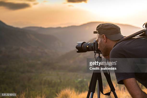 landscape male photographer in action taking picture - spiegelreflexcamera stockfoto's en -beelden