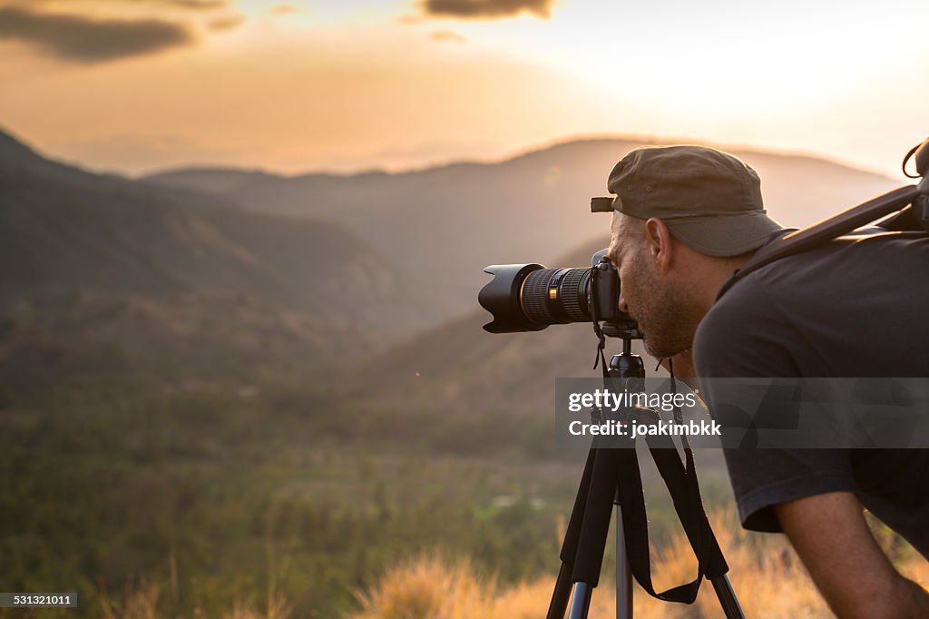 Landscape male photographer in action taking picture