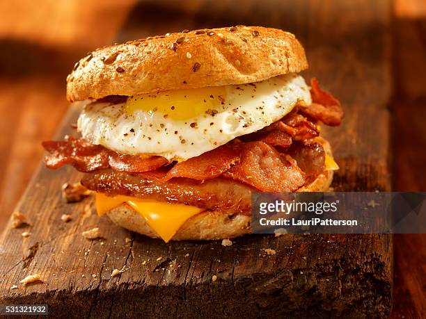 bagel, speck, würstchen und eier frühstücks-sandwich - breakfast sausage stock-fotos und bilder