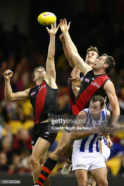 Michael Hartley and Matthew Leuenberger of the Bombers compete for the ball as Todd Goldstein of the Kangaroos looks on during the round eight AFL...