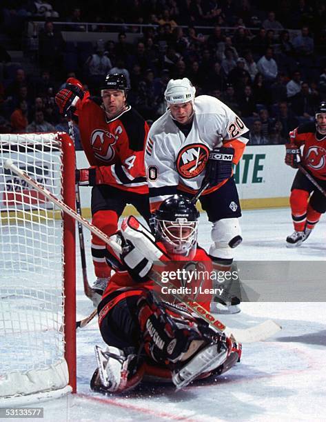 New Jersey goaltender Chris Terreri makes sliding stick save while Scott Stevens and Bryan Smolinski look on.