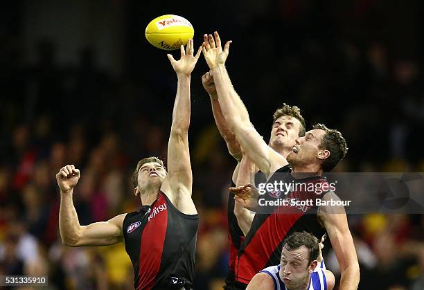 Michael Hartley and Matthew Leuenberger of the Bombers compete for the ball as Todd Goldstein of the Kangaroos looks on during the round eight AFL...