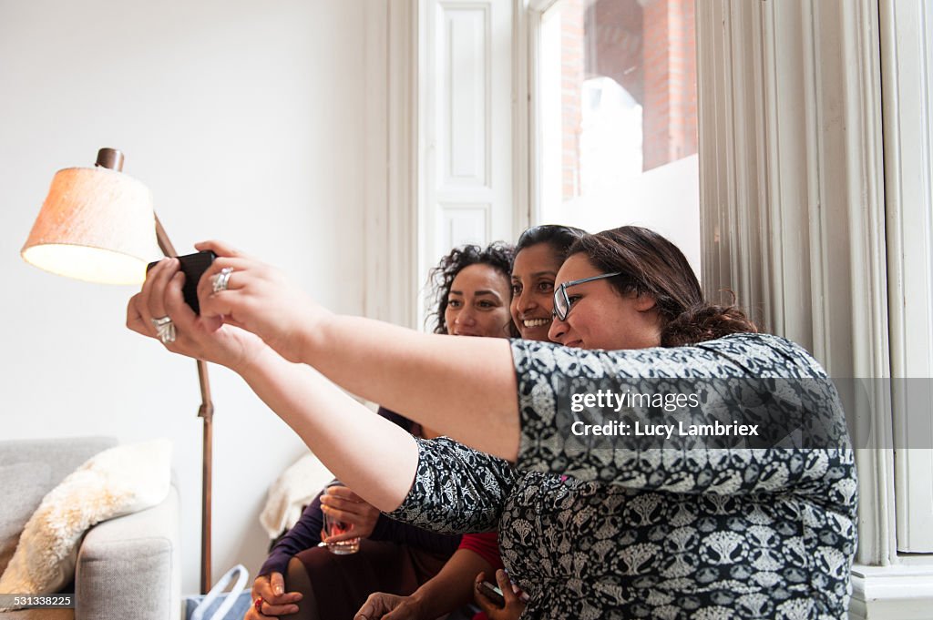 Three women making a selfie at home