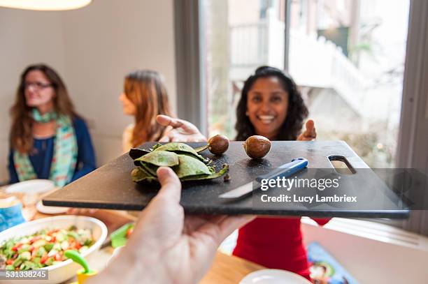 woman handing avocado peels to the viewer - personal perspective or pov stockfoto's en -beelden