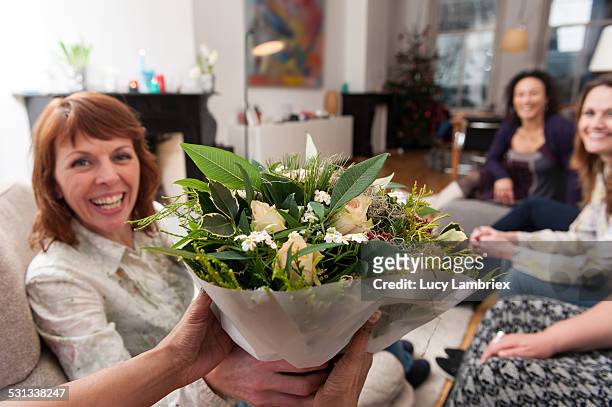 woman handing a bunch of flowers to the viewer - personal perspective or pov stockfoto's en -beelden