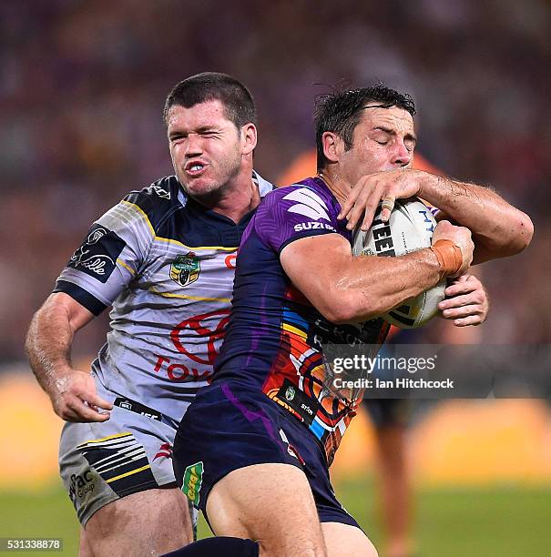 Cooper Cronk of the Storm is tackled by Lachlan Coote of the Cowboys during the round 10 NRL match between the Melbourne Storm and the North...