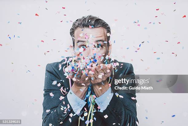 business man blowing confetti. - business celebration ストックフォトと画像