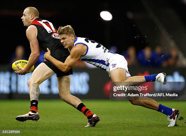 Adam Cooney of the Bombers is tackled by Mason Wood of the Kangaroos during the 2016 AFL Round 08 match between the Essendon Bombers and the North...