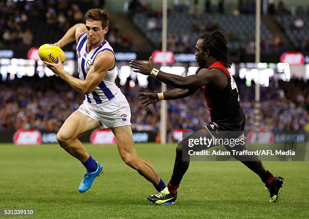 Shaun Atley of the Kangaroos is tackled by Anthony McDonald-Tipungwuti of the Bombers during the 2016 AFL Round 08 match between the Essendon Bombers...