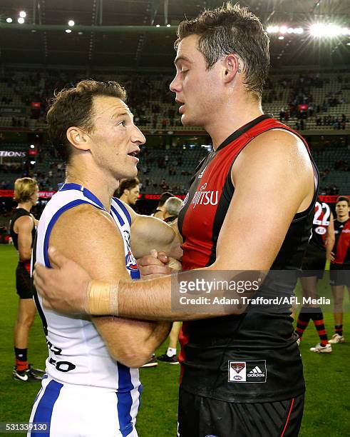 Nathan Grima of the Bombers shakes hands with former teammate Brent Harvey of the Kangaroos during the 2016 AFL Round 08 match between the Essendon...