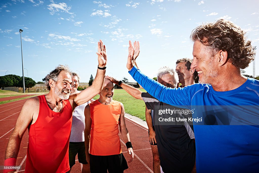 Mature runners cheering on track