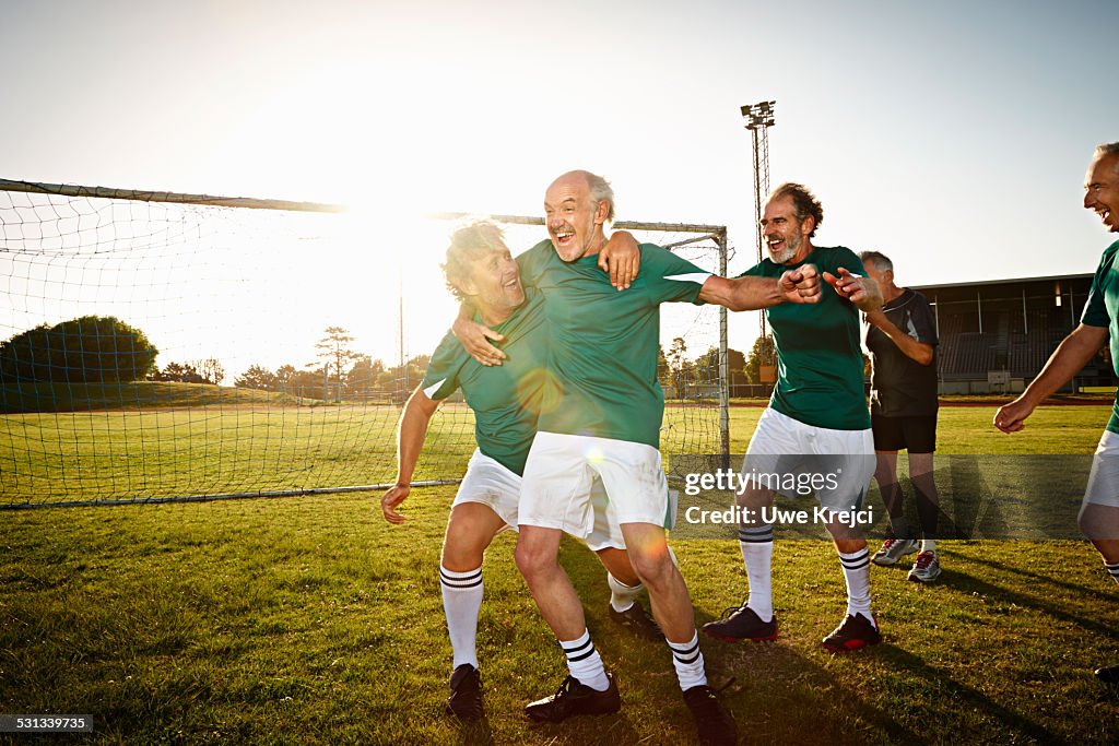 Mature soccer players cheering