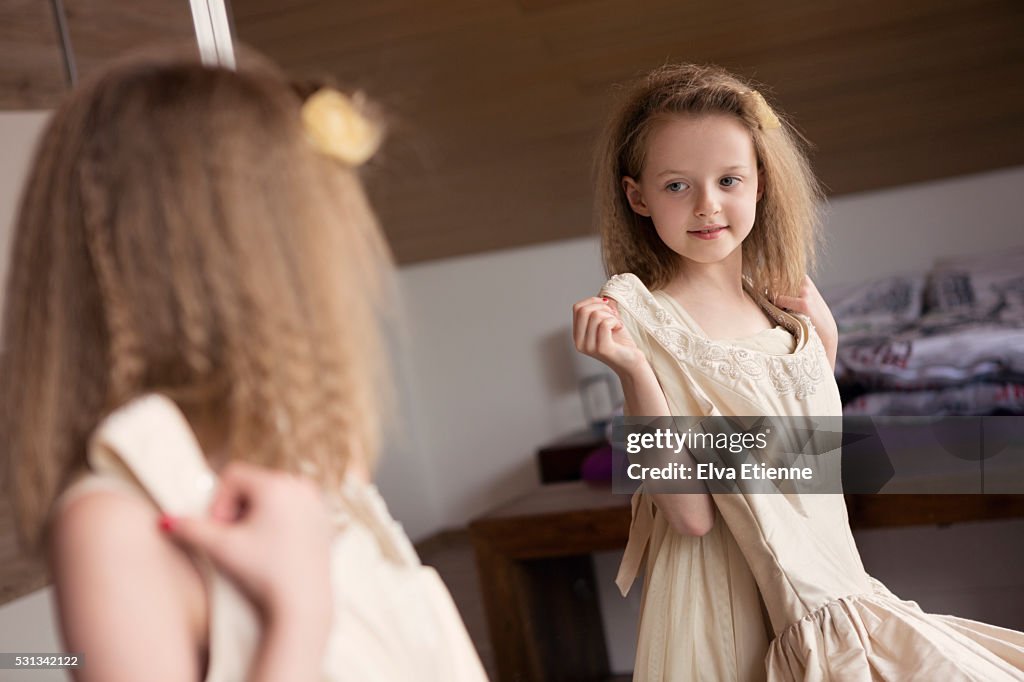 Girl (8-9) playing with a wedding dress