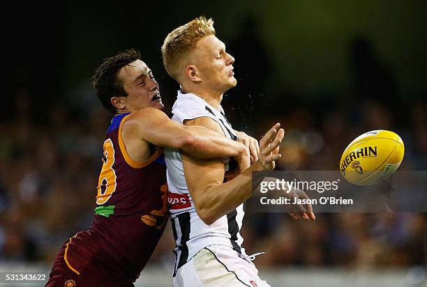 Adam Treloar of the magpies is tackled by Ben Sinclair of the lions during the round eight AFL match between the Brisbane Lions and the Collingwood...