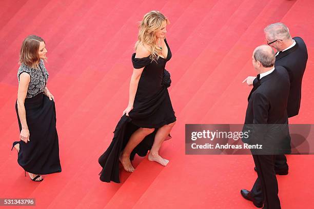 Actress Julia Roberts walks barefoot upon her arrival as producer Jodie Foster smiles at the 'Money Monster' premiere during the 69th annual Cannes...