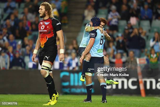 Snyman of the Bulls looks dejected as Andrew Kellaway and Dean Mumm of the Waratahs celebrate a try by Mumm during the round 12 Super Rugby match...