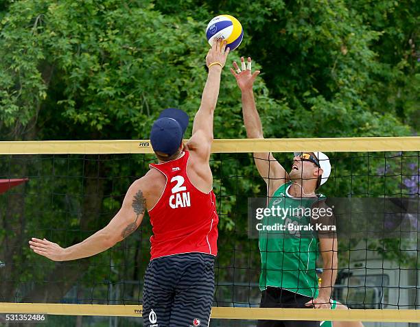 Sam Pedlow of Canada jumps to spike the Mikasa past a blocking Bartosz Losiak of Poland during the 5th day of the FIVB Antalya Open beach volley...