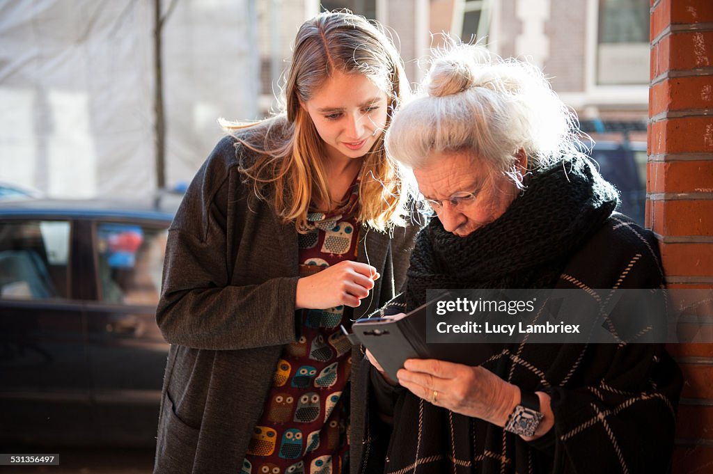 Senior lady and grandchild looking at smartphone