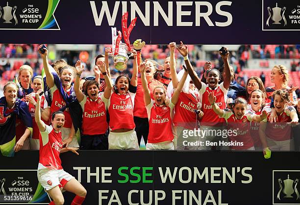 Captain Alex Scott of Arsenal lifts the trophy with team mates as they celebrate victory after the SSE Women's FA Cup Final between Arsenal Ladies...