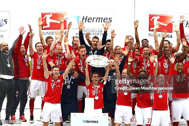 Captian Philipp Lahm of Bayern Muenchen lifts the Meisterschale as players and staffs celebrate the Bundesliga champions after the Bundesliga match...