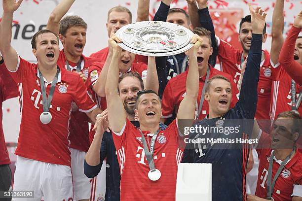 Robert Lewandowski of Bayern Muenchen lifts the Meisterschale as players and staffs celebrate the Bundesliga champions after the Bundesliga match...