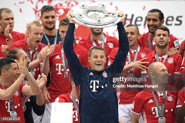 Manuel Neuer of Bayern Muenchen lifts the Meisterschale as players and staffs celebrate the Bundesliga champions after the Bundesliga match between...