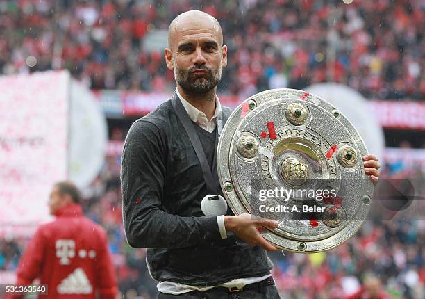 Team coach Josep Guardiola of Bayern Muenchen celebrates with the German Championship trophy after the Bundesliga match between FC Bayern Muenchen...