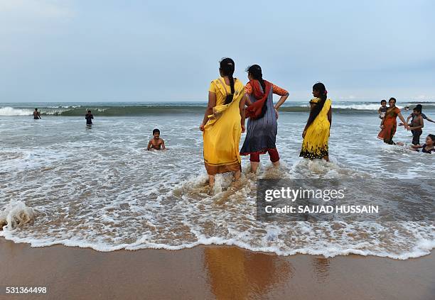 Indian visitors swim at Rushikonda Beach in Visakhapatnam on May 14, 2016. / AFP / SAJJAD HUSSAIN