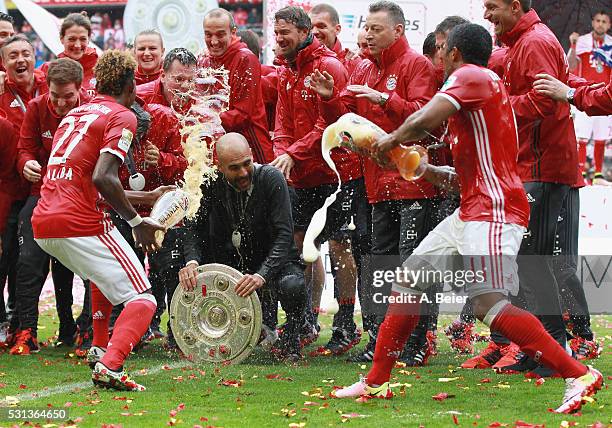 Team coach Josep Guardiola of Bayern Muenchen receives a beer shower from David Alaba and Douglas Costa during the German Championship celebration...