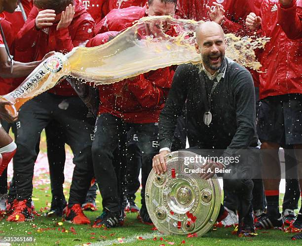 Team coach Josep Guardiola of Bayern Muenchen receives a beer shower from David Alaba during the German Championship celebration after the Bundesliga...
