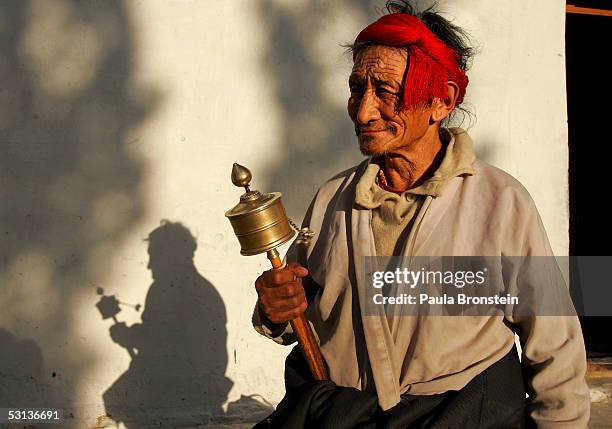 Year old Karma Kendup spins his prayer wheel outside an old age home for elderly Tibetan refugees June 20, 2005 in Choglamsar, Ladakh, India. Ladakh...